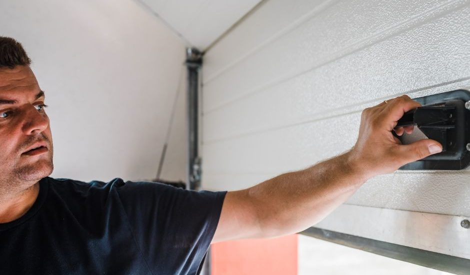 A technician from Bulldog Garage Door Repair conducting preventive maintenance on a garage door.