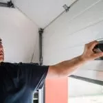 A technician from Bulldog Garage Door Repair conducting preventive maintenance on a garage door.