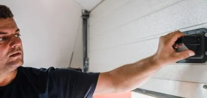 A technician from Bulldog Garage Door Repair conducting preventive maintenance on a garage door.