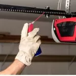 A technician from Bulldog Garage Door Repair conducting preventive maintenance on a garage door.